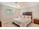 This cozy bedroom features a ceiling fan, window with blinds, and a comfy queen-size bed with wood headboard at 4214 Groveland Ave, Sarasota, FL 34231