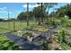 Community garden with raised garden plots featuring a variety of plants and weed-control fabric at 4214 Groveland Ave, Sarasota, FL 34231