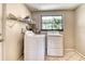 This functional laundry room includes a washer, dryer, and convenient shelving for storage at 4214 Groveland Ave, Sarasota, FL 34231