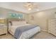 Serene bedroom with natural light, ceiling fan, a cozy bed, and white dresser at 4214 Groveland Ave, Sarasota, FL 34231