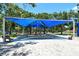 Covered playground featuring climbing structures, swings, and slides with shade for enjoyable outdoor play at 4214 Groveland Ave, Sarasota, FL 34231