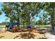 A colorful playground with slides and climbing structures under the shade of mature trees in the community at 4214 Groveland Ave, Sarasota, FL 34231