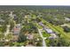 Aerial view showcasing neighborhood homes, streets, green spaces, and mature trees at 4357 Mermell Cir, North Port, FL 34291