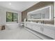 Modern bathroom with soaking tub, marble floors, double vanity, and an illuminated mirror at 455 Cleveland Dr, Sarasota, FL 34236