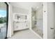 Modern bathroom featuring a double vanity, glass-enclosed shower, and bright natural light at 455 Cleveland Dr, Sarasota, FL 34236