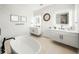 Bright bathroom featuring double vanities, soaking tub, tile floors, and modern lighting at 455 Cleveland Dr, Sarasota, FL 34236