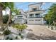 Stunning modern white home featuring a brick driveway, multiple balconies, and lush landscaping at 455 Cleveland Dr, Sarasota, FL 34236