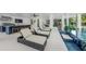 A luxurious pool area with lounge chairs, an outdoor kitchen, and stylish bar seating at 455 Cleveland Dr, Sarasota, FL 34236