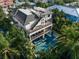 Aerial view of the pool with seating, bar, and outdoor living area, set amidst lush greenery at 455 Cleveland Dr, Sarasota, FL 34236