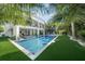 A luxurious swimming pool surrounded by lush green artificial turf and tropical landscaping at 455 Cleveland Dr, Sarasota, FL 34236
