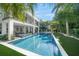A sparkling swimming pool surrounded by lush landscaping and a modern home at 455 Cleveland Dr, Sarasota, FL 34236