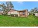 Charming single-story home with a well maintained lawn, mature trees, and a small sunroom at 495 Oak Hill Cir # 44, Sarasota, FL 34232