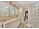 Bathroom with dual sinks, vanity, large mirrors, and unique glass block accents at 495 Oak Hill Cir # 44, Sarasota, FL 34232