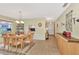 Open-concept dining room with a wooden table, six chairs, and decorative wall sconces at 495 Oak Hill Cir # 44, Sarasota, FL 34232