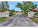 Community entrance with 'Village Oaks' signage, lush landscaping, and tree-lined driveways at 495 Oak Hill Cir # 44, Sarasota, FL 34232
