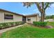 Home's front exterior featuring a well-maintained lawn, lush hedges, and a charming walkway at 495 Oak Hill Cir # 44, Sarasota, FL 34232