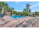 Outdoor pool area with lounge chairs, lush landscaping and palm trees at 495 Oak Hill Cir # 44, Sarasota, FL 34232