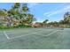 Outdoor tennis court ready for a match surrounded by lush trees and neighborhood views at 495 Oak Hill Cir # 44, Sarasota, FL 34232