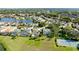 Aerial view of a property with screened pool, lush landscaping, and a tennis court in a lakeside community at 5078 47Th W St, Bradenton, FL 34210