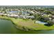 An aerial view showing a lakeside property featuring a tennis court, well-kept lawns, and beautiful landscaping at 5078 47Th W St, Bradenton, FL 34210