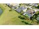 Aerial view of a property with screened pool, lush landscaping, and a tennis court in a lakeside community at 5078 47Th W St, Bradenton, FL 34210