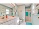 Refreshing bathroom featuring dual sinks, light blue walls, and a tiled walk-in shower for a spa-like experience at 5078 47Th W St, Bradenton, FL 34210