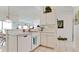 Bright kitchen featuring white cabinets and appliances, and a breakfast bar overlooking the living area at 5078 47Th W St, Bradenton, FL 34210