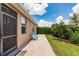 Landscaped backyard with patio featuring light blue chairs, lush green lawn, and well-maintained bushes at 5301 Shell Mound Cir, Punta Gorda, FL 33982