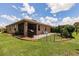 Fenced backyard with patio, grill, seating, and lush lawn, great for outdoor activities and entertaining at 5301 Shell Mound Cir, Punta Gorda, FL 33982
