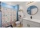 Bathroom features updated vanity, with a framed circular mirror and a shower with a blue starfish-themed curtain at 5301 Shell Mound Cir, Punta Gorda, FL 33982