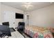 A comfortable bedroom with room for a desk area and a bed with a brightly patterned comforter and ceiling fan at 5301 Shell Mound Cir, Punta Gorda, FL 33982