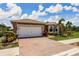 Home with brick driveway and landscaped front yard featuring mature landscaping at 5301 Shell Mound Cir, Punta Gorda, FL 33982