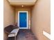 Inviting front entryway with a blue door, bench and a 'Welcome' sign at 5301 Shell Mound Cir, Punta Gorda, FL 33982