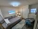 Cozy bedroom features a double bed, stylish chair, and laminate flooring, illuminated by modern lighting at 5402 Chateau Ln, Bradenton, FL 34207