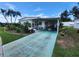 Home with colorful driveway, carport, mature landscaping, and exterior awning at 5402 Chateau Ln, Bradenton, FL 34207