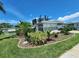 Beautifully landscaped front yard with lush greenery, tropical plants, and a well-maintained lawn at 5402 Chateau Ln, Bradenton, FL 34207