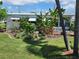 Landscaped front yard with tropical plants, vibrant greenery, and a well-maintained lawn at 5402 Chateau Ln, Bradenton, FL 34207