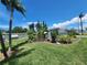 Beautiful front yard featuring lush landscaping, mature trees, and well-maintained grass at 5402 Chateau Ln, Bradenton, FL 34207