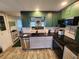 Updated kitchen featuring modern appliances, dark countertops, and stylish green cabinets at 5402 Chateau Ln, Bradenton, FL 34207