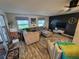 Spacious living room featuring a comfortable sectional sofa, large windows, and modern decor at 5402 Chateau Ln, Bradenton, FL 34207