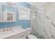 Modern bathroom with blue walls, marble tiled shower and quartz countertop vanity at 6016 Hibiscus Dr, Bradenton, FL 34207