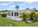 Exterior view showcasing a white sunroom, white exterior, and well-maintained lawn at 6016 Hibiscus Dr, Bradenton, FL 34207