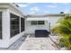 Patio area features a black storage box, AC unit, and white awning near lush greenery at 6016 Hibiscus Dr, Bradenton, FL 34207
