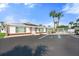 Exterior of a well-maintained home featuring ample parking, landscaping, and solar panels at 6016 Hibiscus Dr, Bradenton, FL 34207