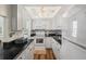 Galley-style kitchen with white cabinets, black countertops, and tile backsplash at 6016 Hibiscus Dr, Bradenton, FL 34207