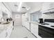 Bright kitchen features white cabinets, granite countertops, stainless steel appliances and a pass through window at 6016 Hibiscus Dr, Bradenton, FL 34207