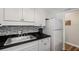 Bright kitchenette with white cabinets, stainless steel sink, and black countertop at 6016 Hibiscus Dr, Bradenton, FL 34207