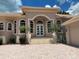 Stunning home featuring a beautiful arched entryway, well-manicured landscaping, and a brick paver driveway at 624 Mourning Dove Dr, Sarasota, FL 34236