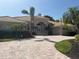 Beautiful home featuring elegant architecture, lush landscaping, and a brick paver driveway leading to a two-car garage at 624 Mourning Dove Dr, Sarasota, FL 34236