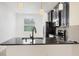 Kitchen with stainless steel appliances, dark cabinets, granite counters, and a breakfast bar at 6454 Baytown Dr, Sarasota, FL 34240